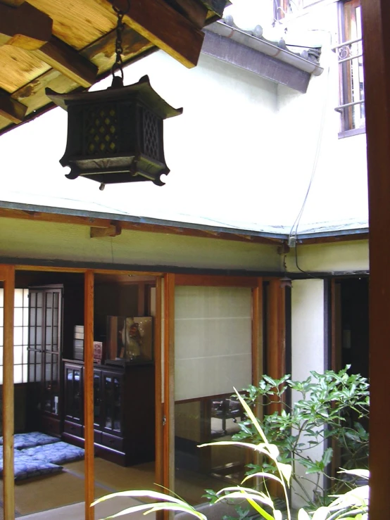 a oriental style lamp hanging from the roof of a home