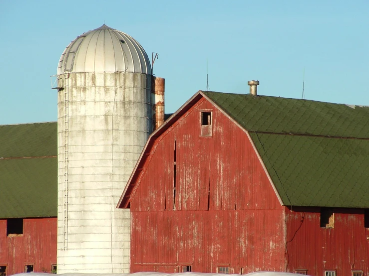 a barn with a very large silo and a silo on top