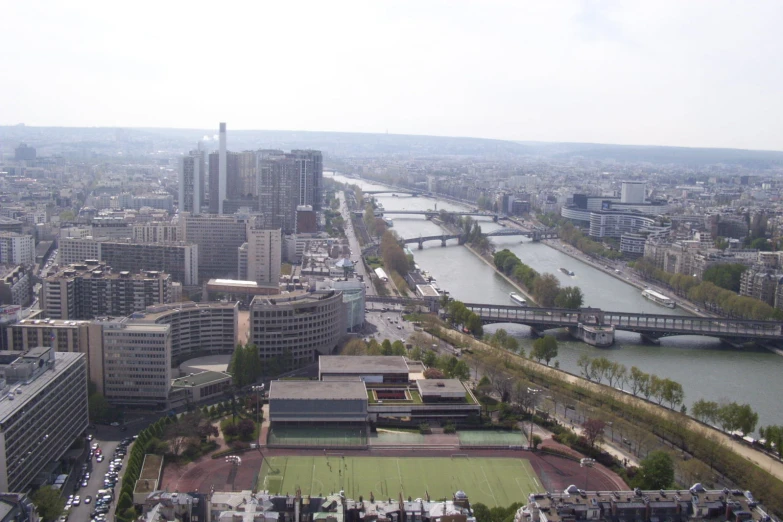 the view from a very tall building shows a wide river and a bridge