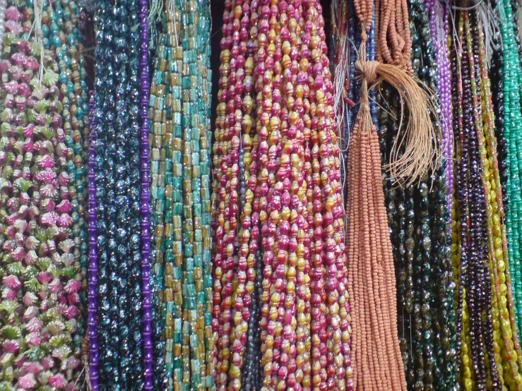 colorful beads are hanging on a wall