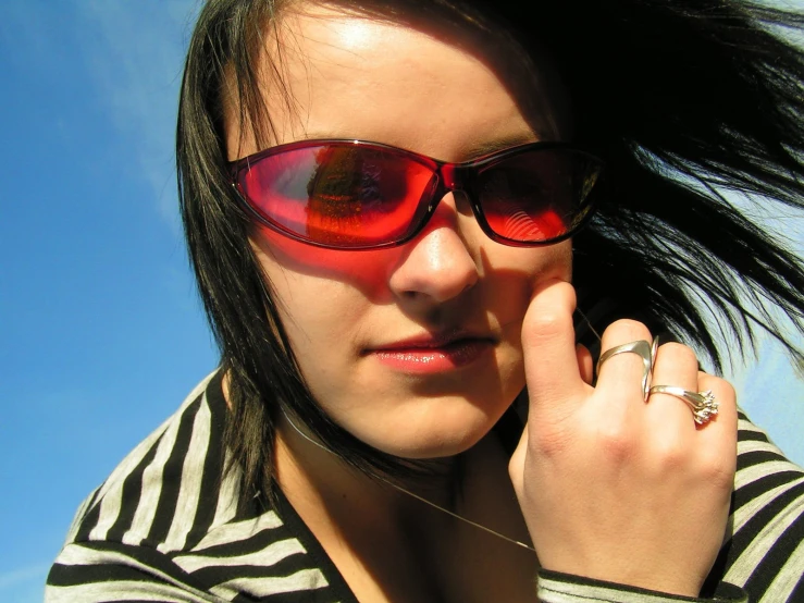 a woman in sun glasses is standing outside
