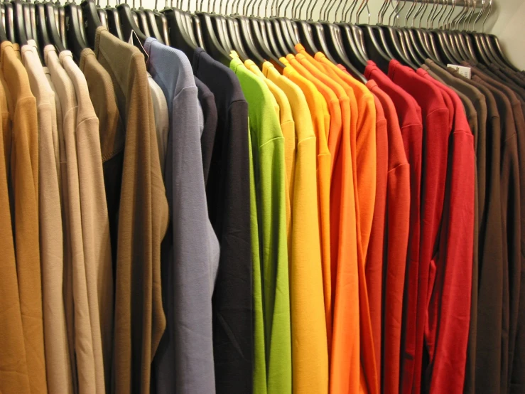 a clothes rack full of different colored clothing