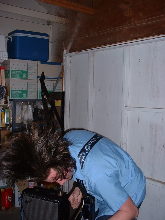 a man kneeling in a room with two old televisions on it's sides