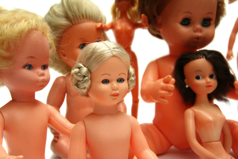 a bunch of small dolls that are on a white surface