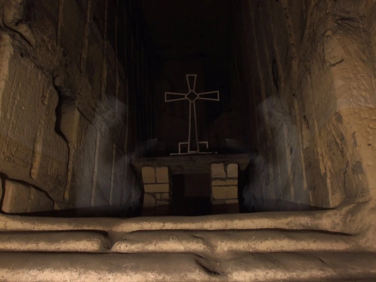 a stone stairway with a cross and window in the distance