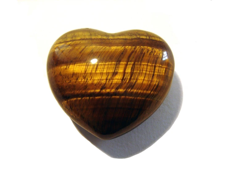 a heart shaped tiger eye cabbale sitting on a white surface