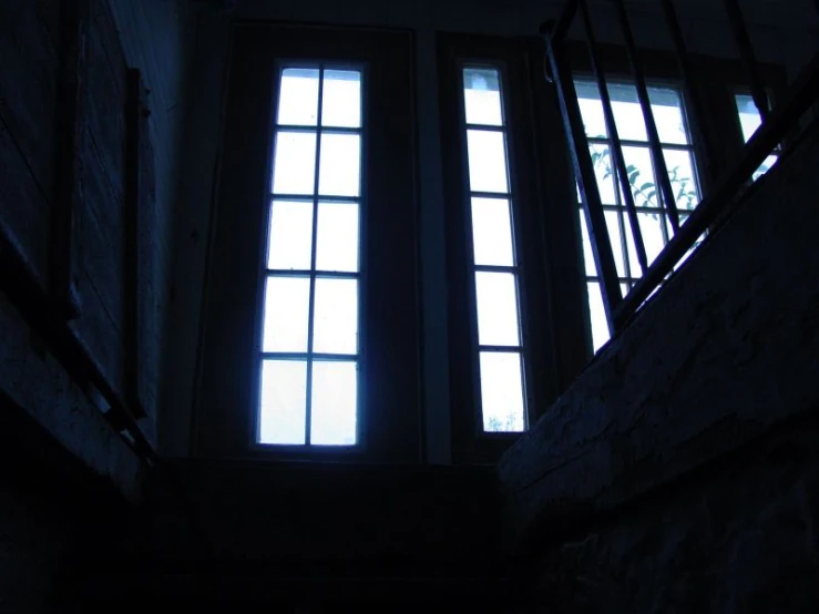 three windows are lit up against a dark background