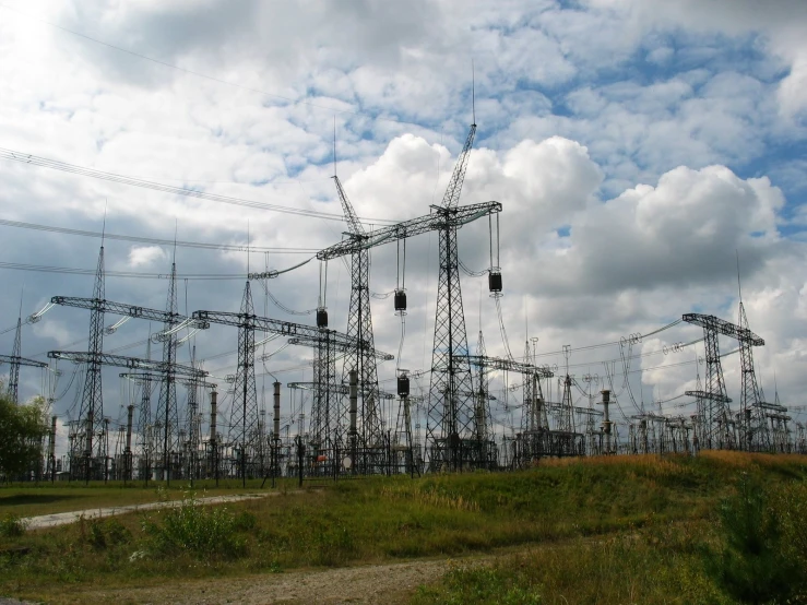 several power lines are in the field with power poles