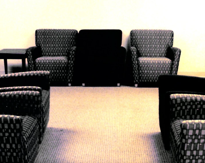 three chairs are facing each other while the room is empty