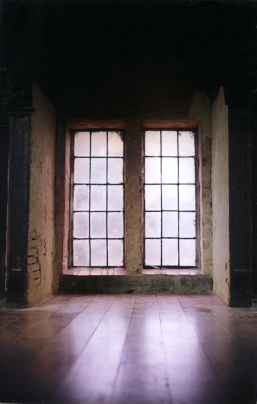 a big window in a stone walled building with tiled floor