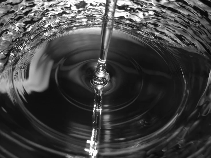 a silver colored faucet being blown water into the air