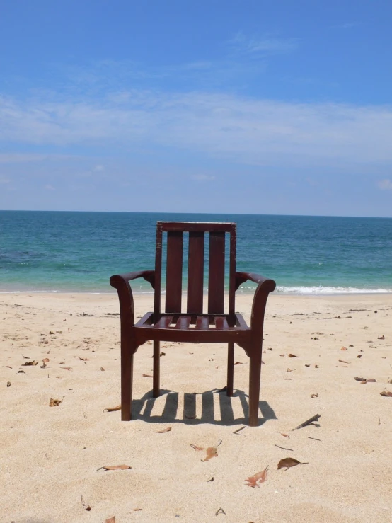 a chair is sitting in the sand on the beach