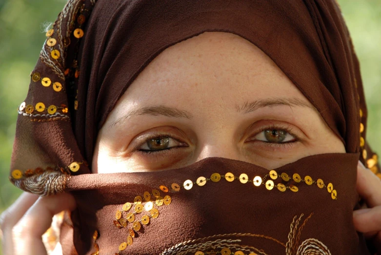 a woman wearing a head covering over her eyes
