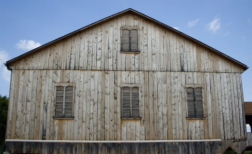 a rustic wooden building with shutters is shown