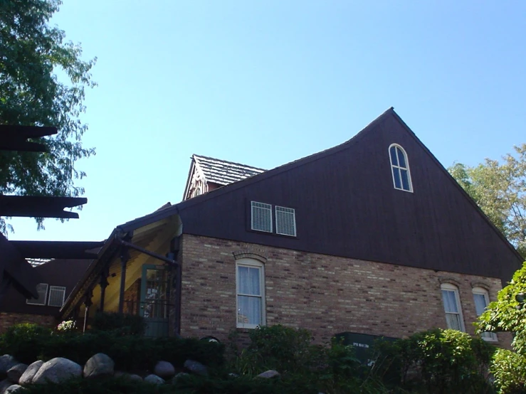 the house is made of brown bricks with a triangle roof