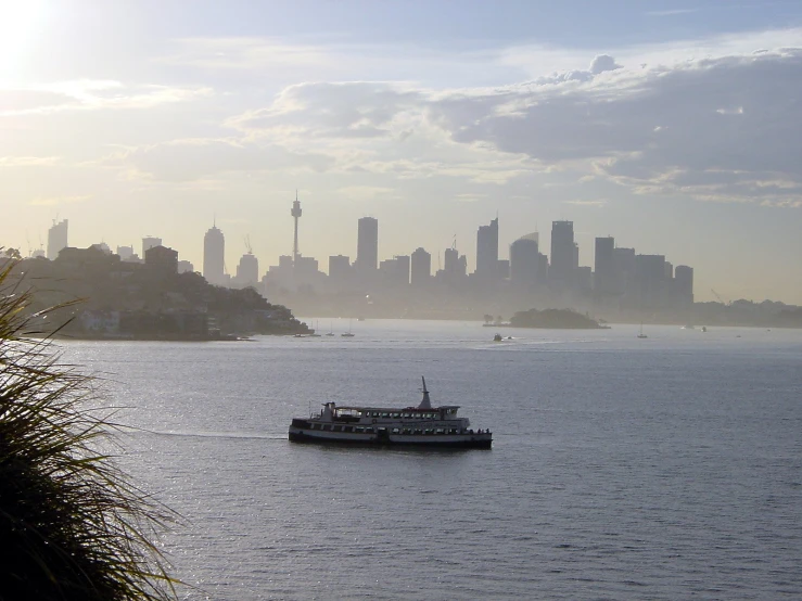 a boat sailing past the city on a very hazy day