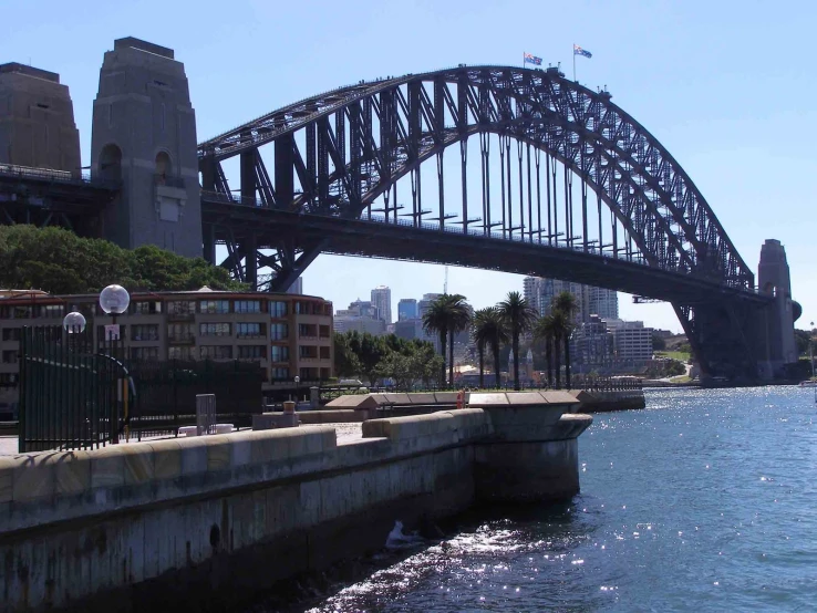 a large bridge spanning a river with buildings in the background