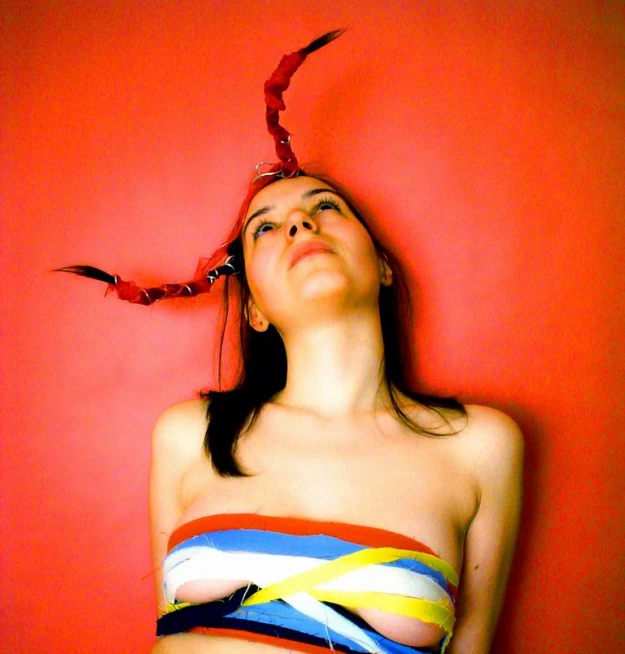 a girl wearing a colorful piece of cloth with a ribbon in her head