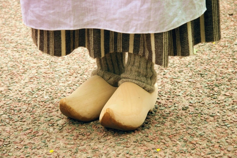 a person standing on the ground with their foot in a pair of cloggly boots