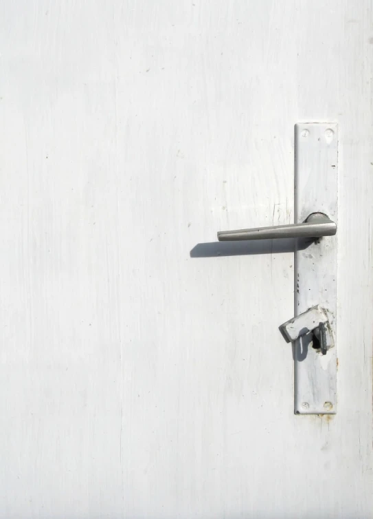 a white door with a latch and handles