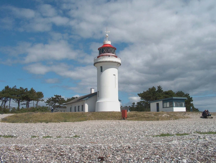 a light house surrounded by small white houses on land