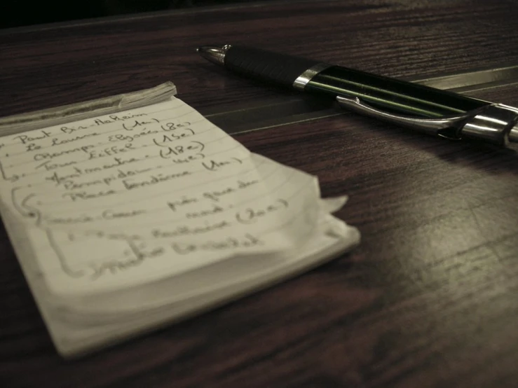 a pen is laying on top of a napkin on the desk