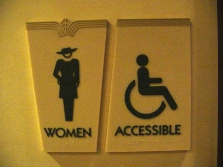 a sign that says women accessible and a woman with a hat is placed on the wall