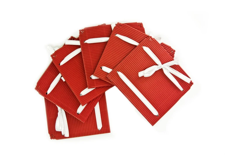 red napkins with white ribbons and bows tied in a knot