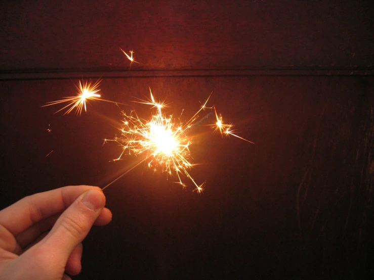 a small person holding a sparkler in their hand