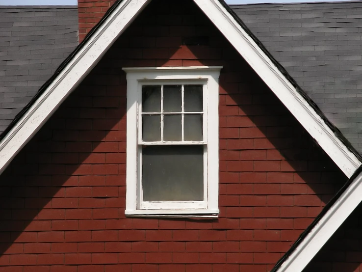 a brick house with two windows on the roof