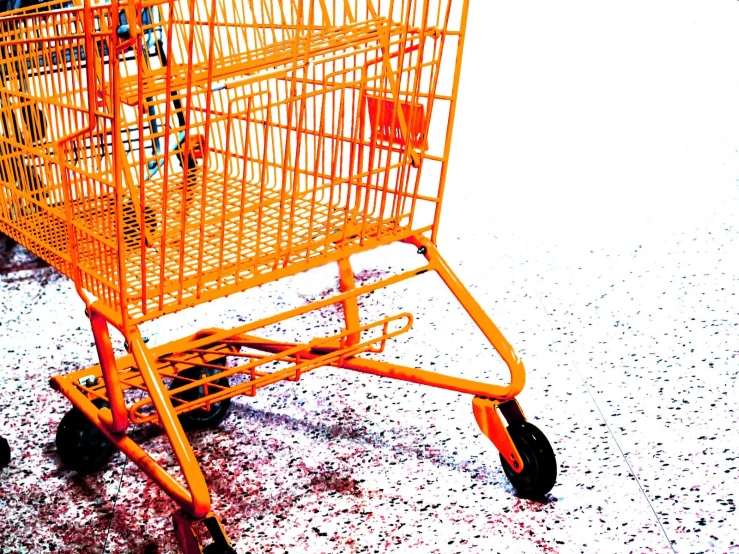 an orange shopping cart on a city street