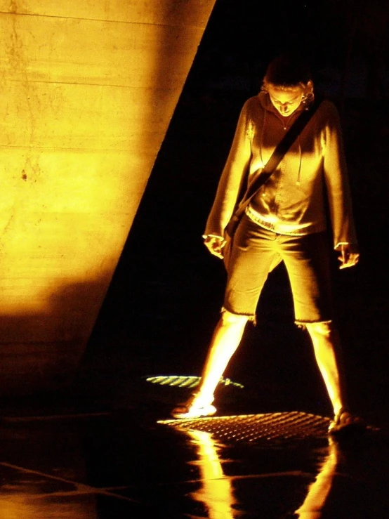 a man in shorts standing on a reflective surface with his lights on