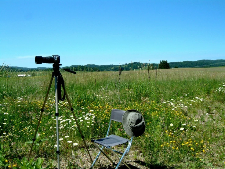 a chair and telescope sitting in a field