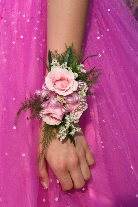 a close - up of a person's pink hand wearing an odd flower celet