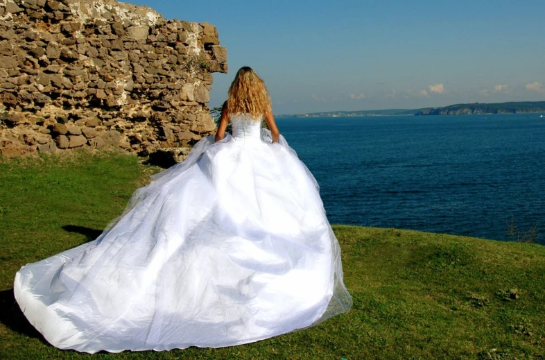 a woman wearing a dress walking by the ocean