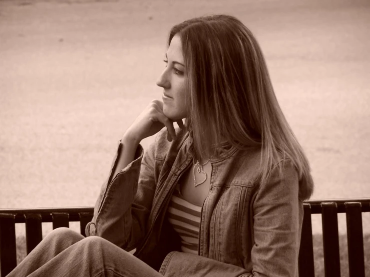 woman sitting on bench with head resting on hand