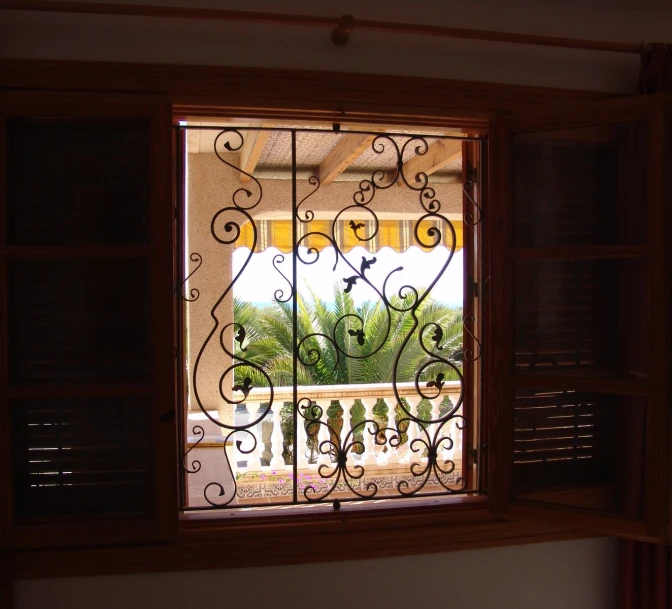 a window that has a fence and iron railing in it