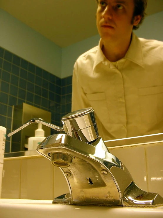 a man stands in front of the bathroom sink