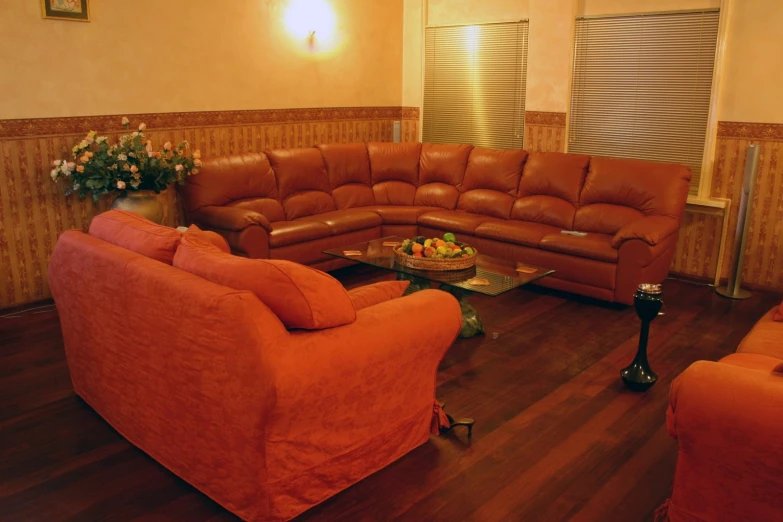 an orange living room with sofas, coffee table, and floral centerpiece