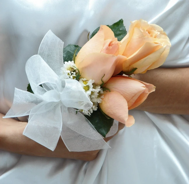 the bride is wearing her bouquet of flowers on her arm