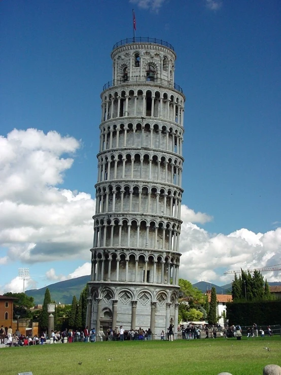 a leaning leaning tower sitting in the middle of a green field