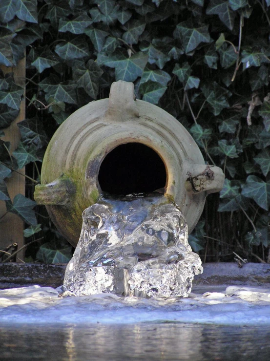 a stone container has a little fountain near it