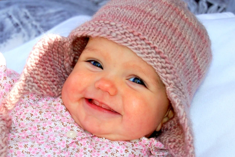 a close up of a baby in pink knitted outfits