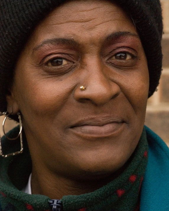 the face of an elderly black woman with a tiny nose piercing