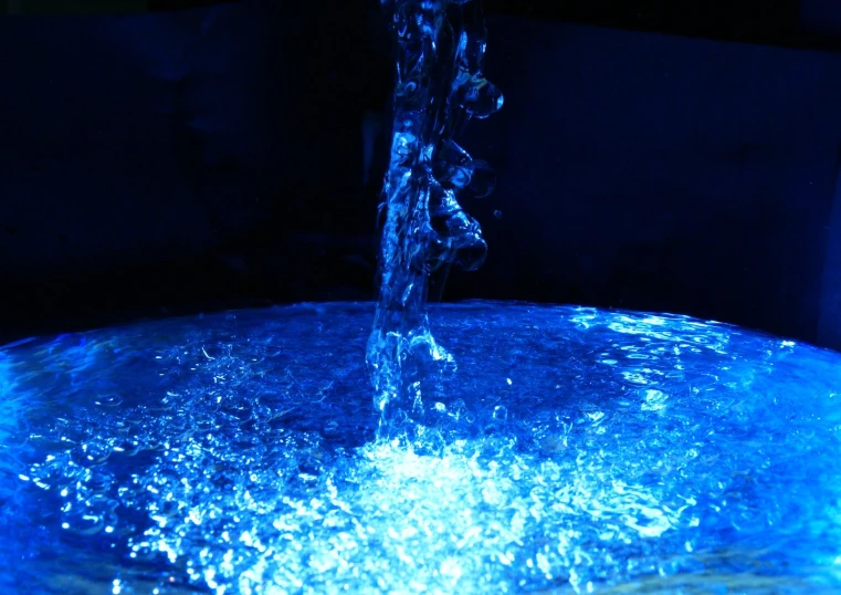 blue light shining down on a water fountain