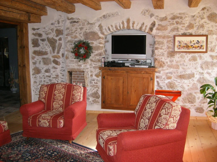 two red chairs in a living room near a television