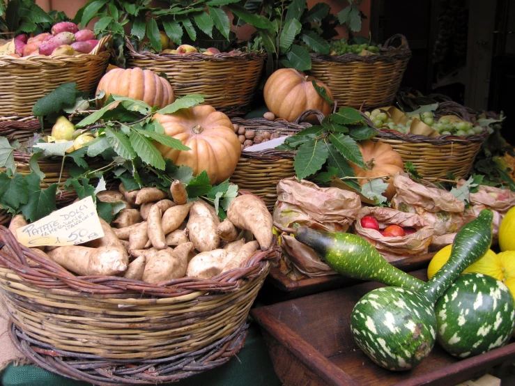 many baskets filled with vegetables such as squash, carrots, and potatoes