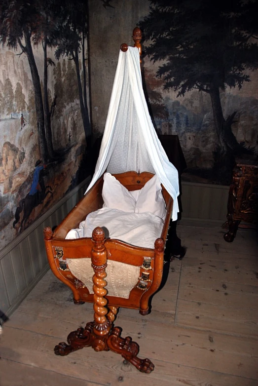 a small bed on wheels with a mosquito net hanging over it