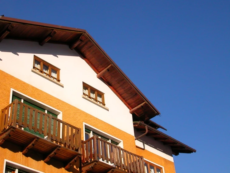 a home with balcony railings and a side building