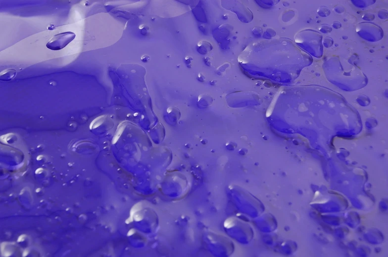 a large, blue liquid has many little drops of water
